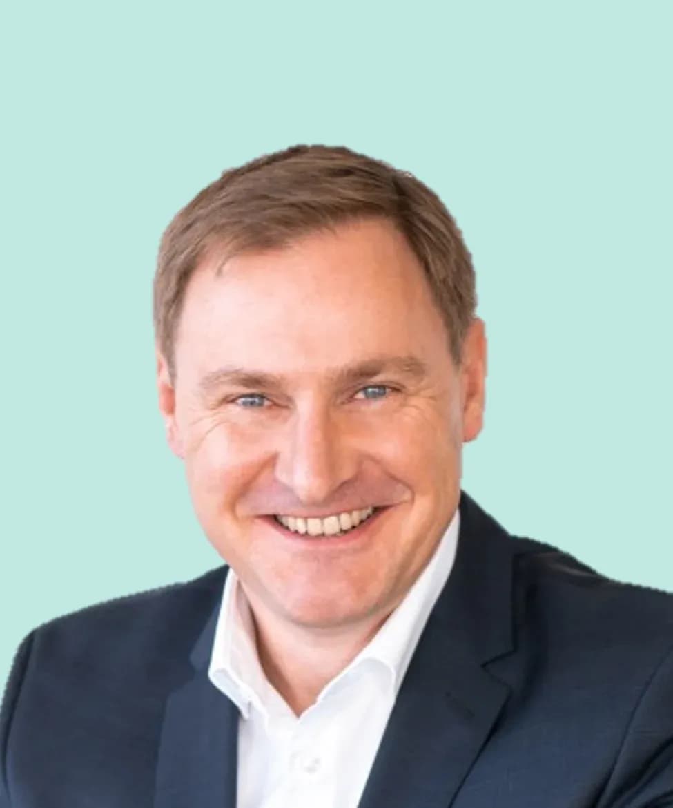 Porträt von Axel Sparnicht vor mintfarbenem Hintergrund
